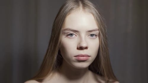 Young Woman Open Eyes on White Background. Close Up of Smiling Girl Looking at Camera in Studio