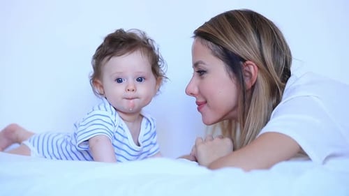Loving Mother with Infant on Bed