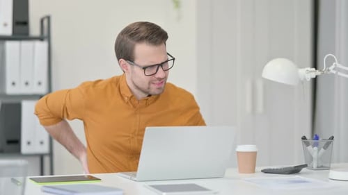 Young Man Having Back Pain in Office