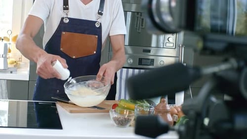 Man Mixing Food Ingredients in Bright Kitchen
