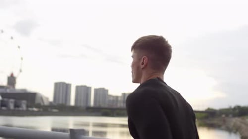 Muscular Male Athlete Jogging on Urban Bridge in Early Morning