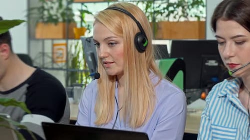 Charmante junge Frau lächelt in die Kamera, arbeitet im Call Center