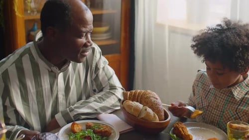 Man and Child Eating Meal Together at Table