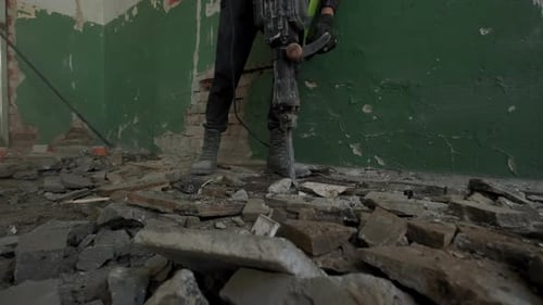 Builder Worker with Pneumatic Hammer Drill Jackhammer Equipment Breaking Concrete Road at Concrete