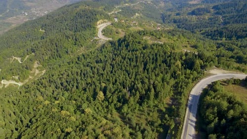 Steep green mountains, deep forest and mountain road, beautiful valley