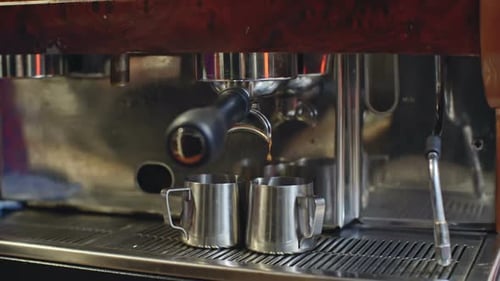 Fresh Espresso Dripping Into Pitchers