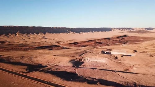 Aerial drone footage of cars on road. Retreat Shot of Cars passing by on desert highway road at sunn