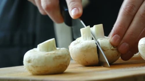 Close up of Knife Cutting White Mushrooms