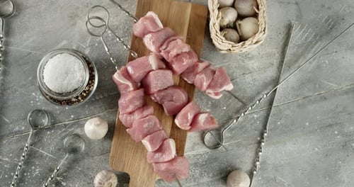 Raw Pork Kebab on Skewers with Spices on the Table.