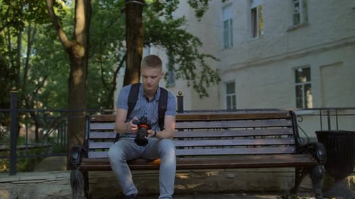 Young Adult Photographer with Camera in Park