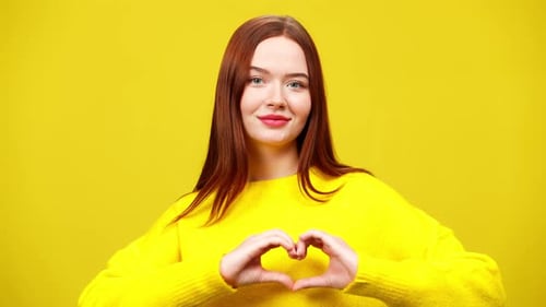 Smiling Woman Makes Heart Shape with Hands