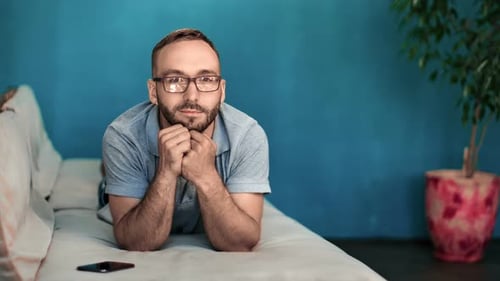 Man Lying on Couch Looking at Camera