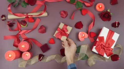 Hands Arranging Gifts, Roses and Candles Flat Lay