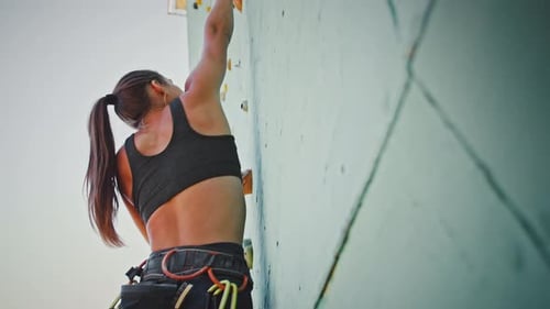 Close Up Shot of Young Woman Climber Going Up on Outdoor Rocky Wall