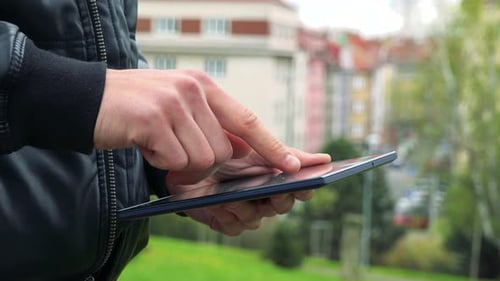 Mann steht und arbeitet auf Tablet-Computer - Detail der Hände mit Tablet-Computer