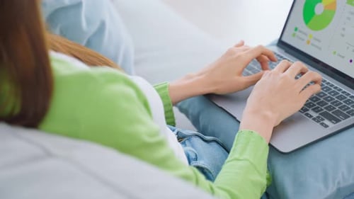 Close up of Asian business woman typing on computer and work in living room at home.
