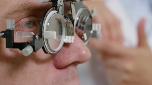 Mann überprüft das Sehvermögen beim Optiker