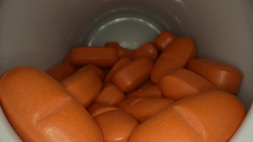 Close-up Inside Bottle of Orange Pills