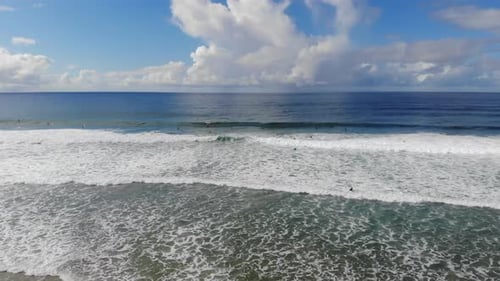 Aerial View of Surfers Riding Waves on Beach