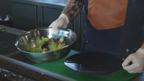 Cook Plating Healthy Salad in Professional Kitchen