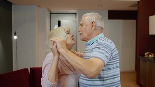 Elderly Couple Dancing Together Lovingly in Living Room