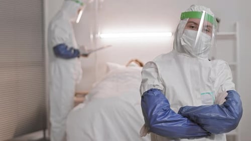 Medical Professionals Wearing Hazmat Suits in Hospital Room