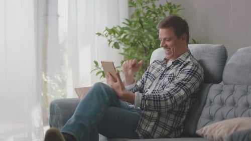 Man Enjoys Video Call on Tablet at Home