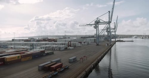Container Shipyard By Port on Horizon of Clear Skies and Cumulonimbus Clouds