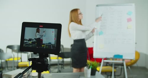 Teacher Giving Presentation at Whiteboard in Classroom