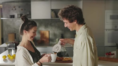 Young Couple Enjoying Coffee Together in Kitchen