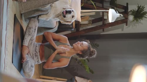 Woman Doing Yoga Exercise with Dog Companion