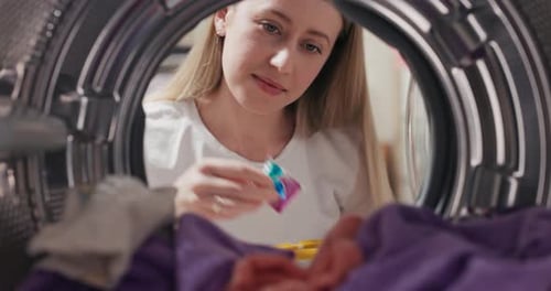 Woman Loading Laundry into Washing Machine