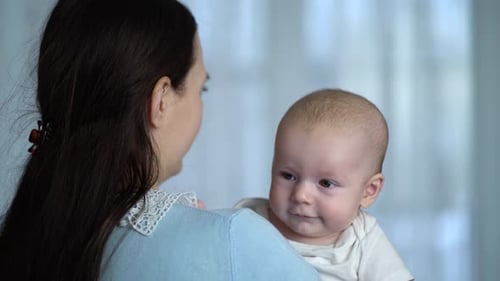 Baby Being Held by Parent Inside a Home