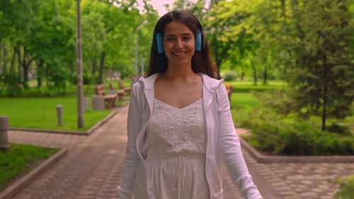 Cheerful Female Enjoy Song Walks in City