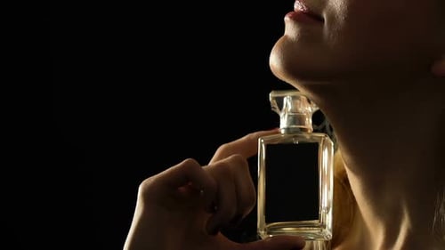 Woman smelling a perfume bottle