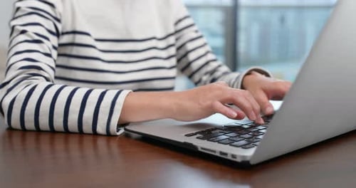 Woman Typing on Laptop at Desk Indoors