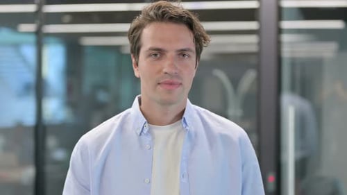 Young Adult Gives Ok Hand Sign in Workplace