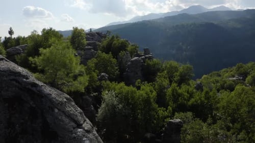 Scenic Landscape View of Rocky Cliffs with Green Trees Surrounded with Mountains