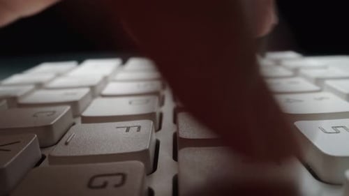 Close-up typing on keyboard with man fingers. Macro soft focus dolly shot.