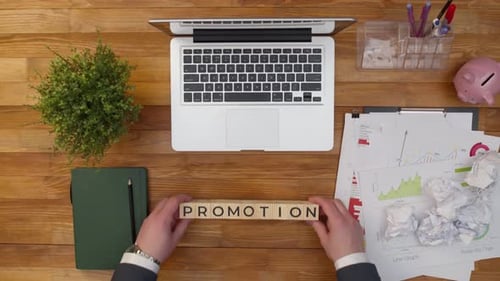 Word Promotion Consists of Wooden Letters in the Form of Cubes on Office Table
