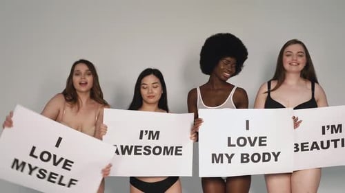 Quatre belles femmes tenant des pancartes avec des affirmations positives