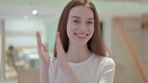 Woman Smiling and Clapping at the Camera