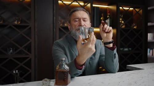 Mature Man with Liquor and Cigar at Bar