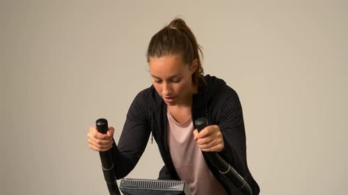 Young Woman Exercising on Stationary Bike Indoors