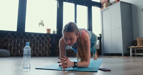 Woman Doing Plank Exercise on Yoga Mat Indoors