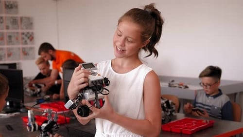 Girl Holding Robot in Bright Classroom Setting