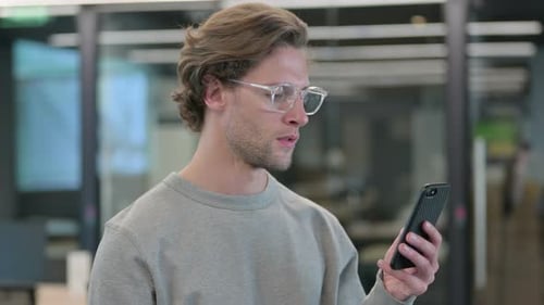 Young Adult Celebrates While Using Mobile Phone