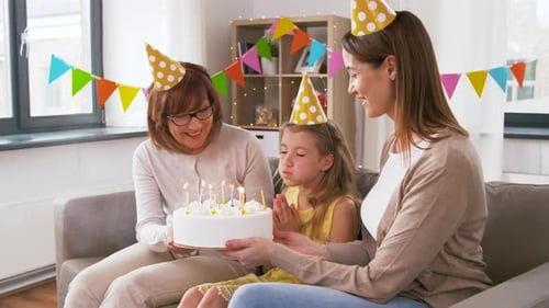 Family Celebrating Birthday at Home with Cake and Candles