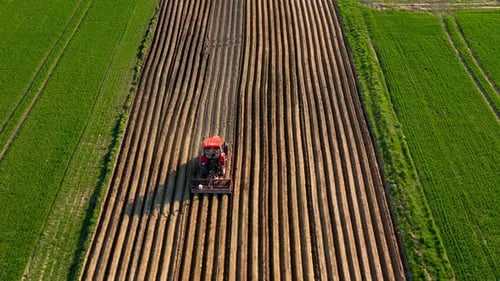 Aerial View of Tractor Performs Seeding on the Field