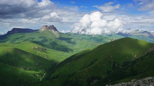 Green Hills and Mountains Under Cloudy Sky
